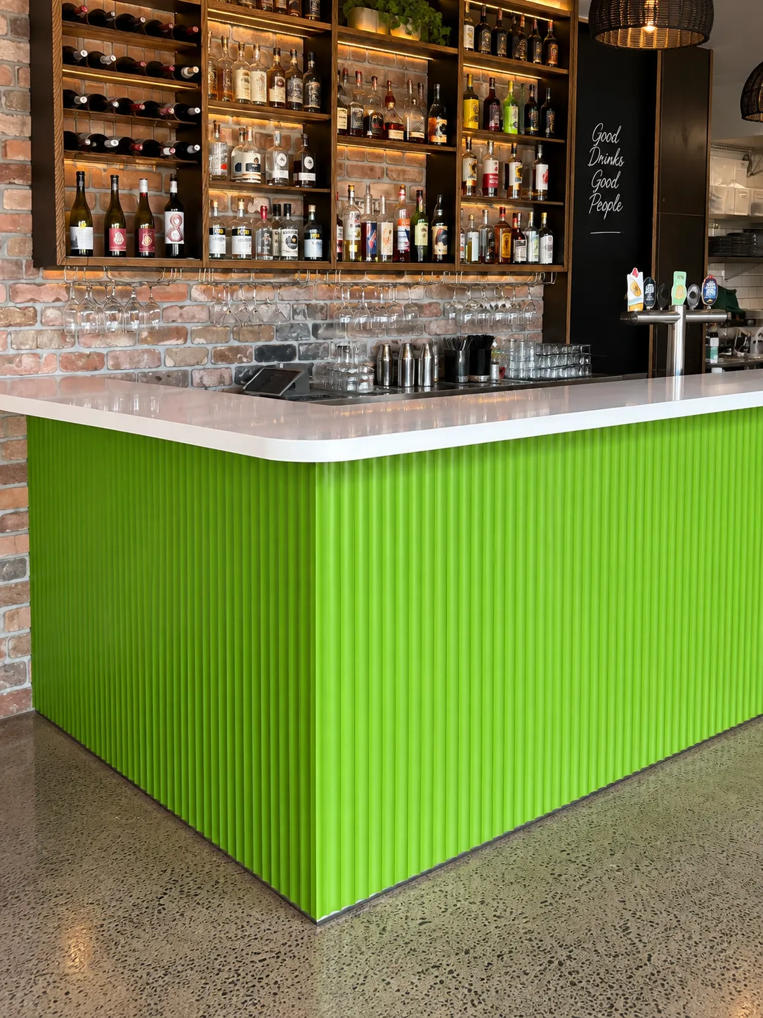 Green fluted bar front in a commercial venue painted by Phelps Painting